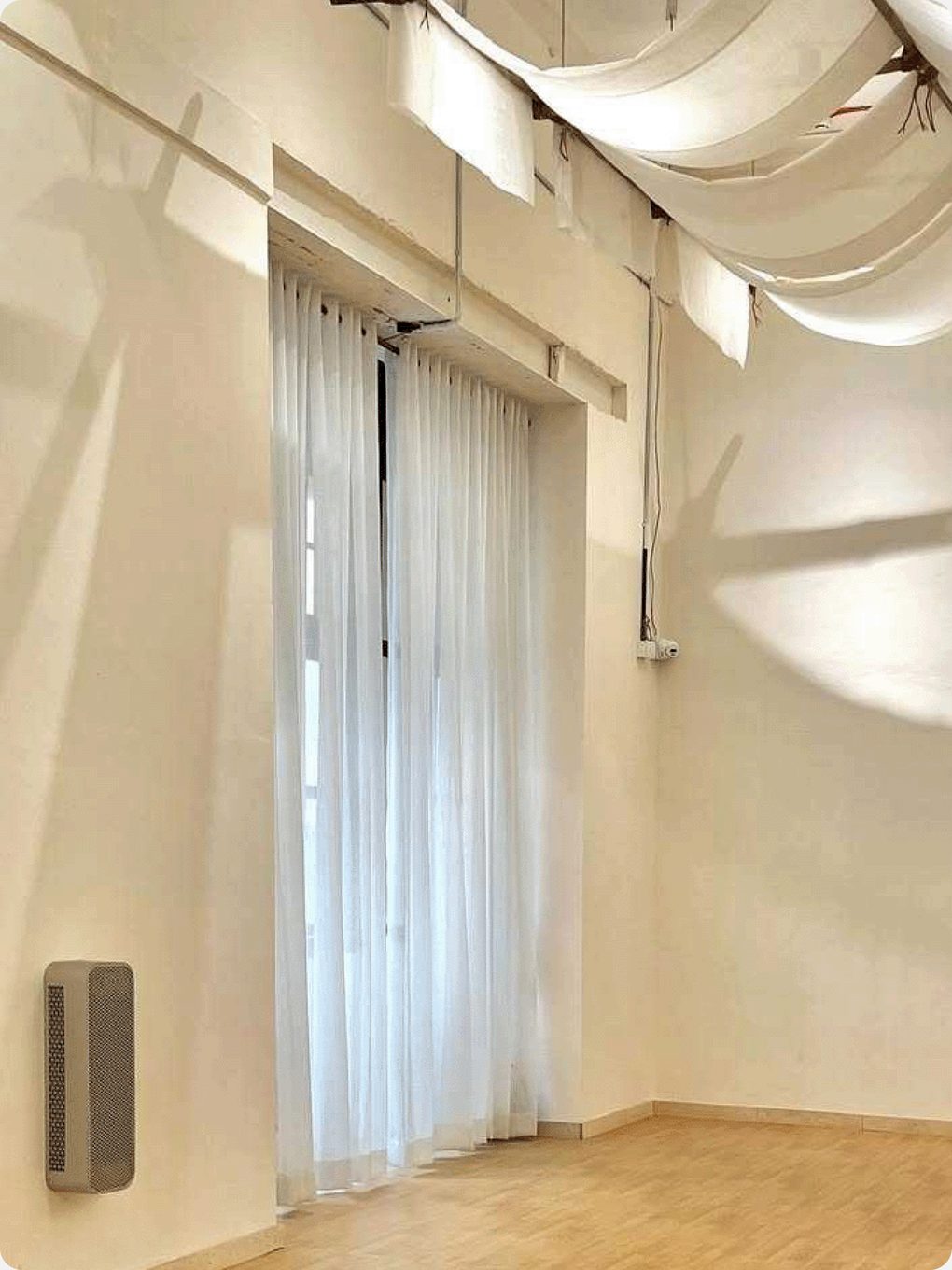HIVE wall-mounted low in a sunlit studio with sheer curtains
