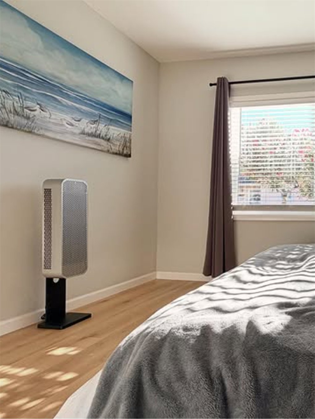 HIVE at the foot of a bed below a seascape painting